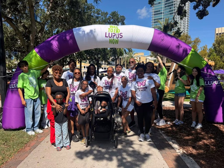 Dr. Cece with family and friends under the Walk to End Lupus Now arch